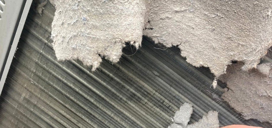 Heavy dust and lint buildup on an HVAC coil that can reduce airflow